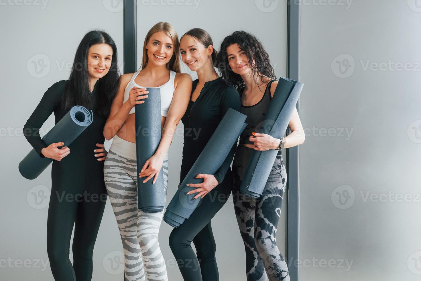 amigos está no ginásio juntos. mulheres em roupas esportivas em pé no centro de fitness foto