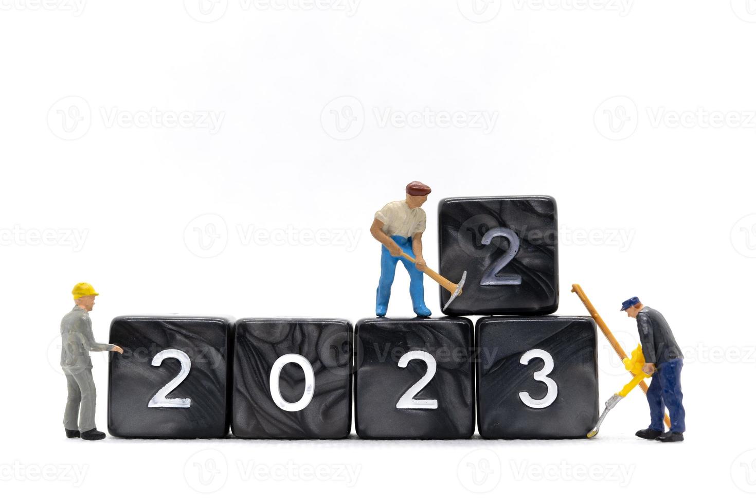 equipe de trabalhadores em miniatura cria o número 2023 no bloco foto