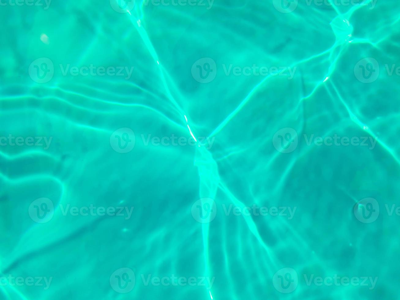 desfocar a textura de superfície de água calma de cor azul transparente turva com salpicos e bolhas. fundo de natureza abstrata na moda. ondas de água na luz solar. fundo de água azul. foto