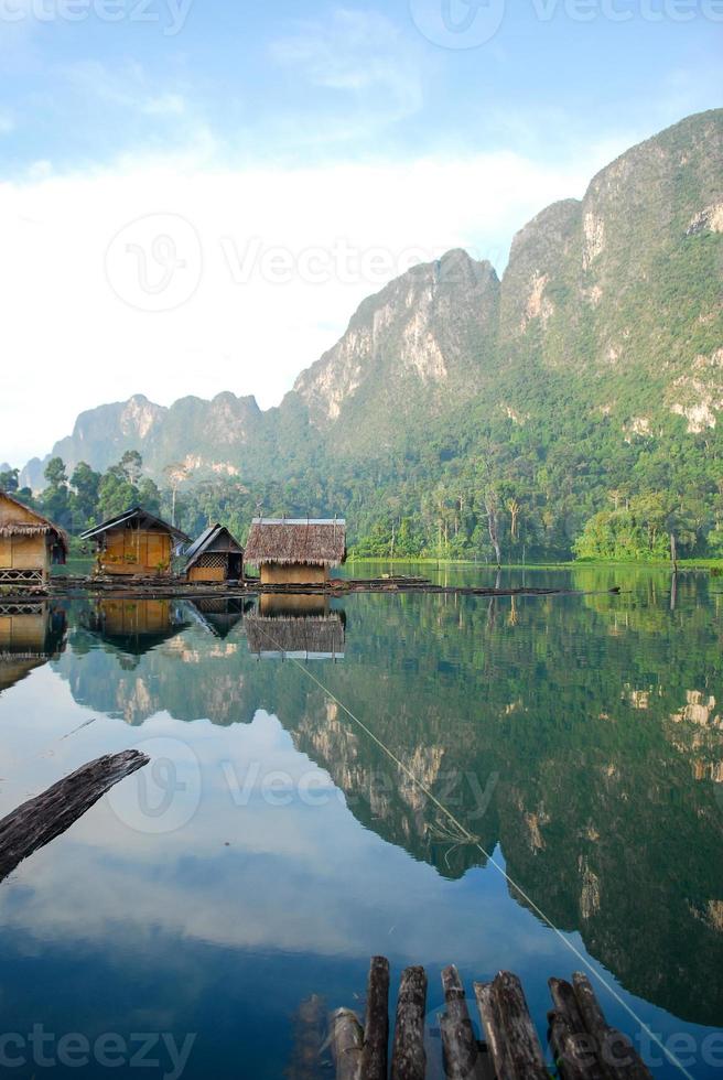 cabana à beira do lago tropical e barco de madeira foto