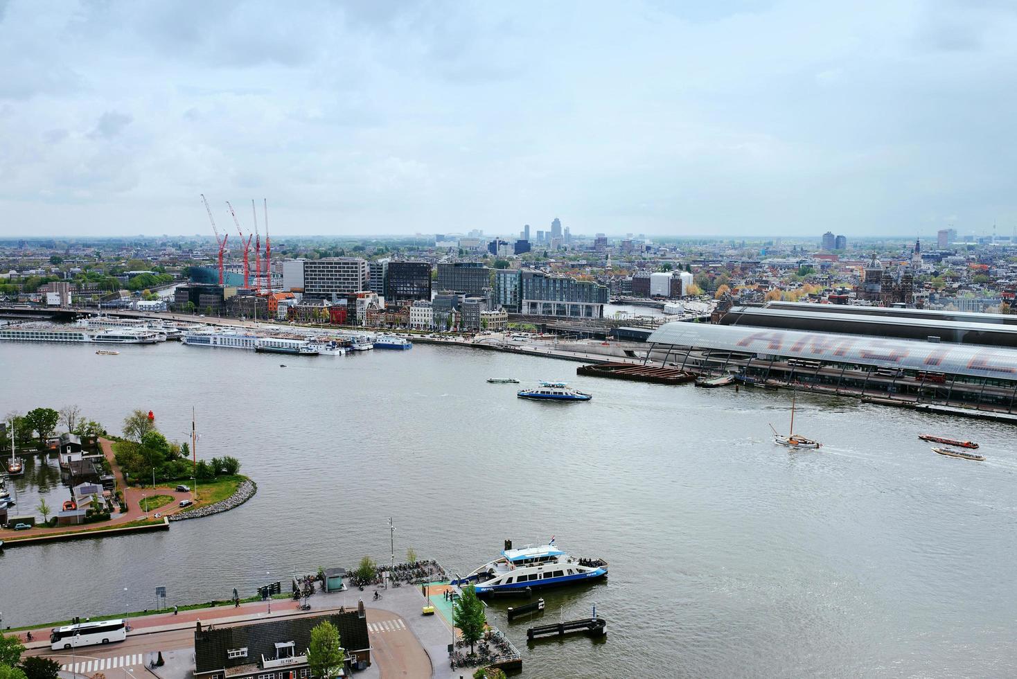 amsterdam, holanda - 28 de abril de 2019 vista da cidade para a parte central da cidade, balsa e canal de cima em dia holandês típico nublado. foto