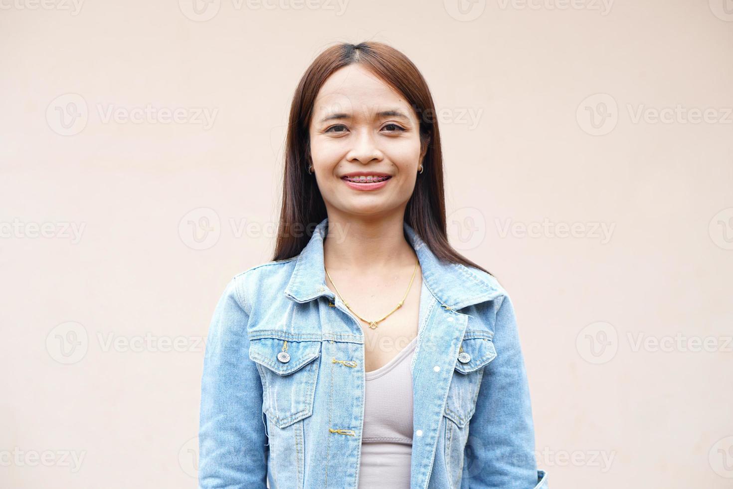 mulher asiática sorrindo alegremente fundo de parede cinza foto