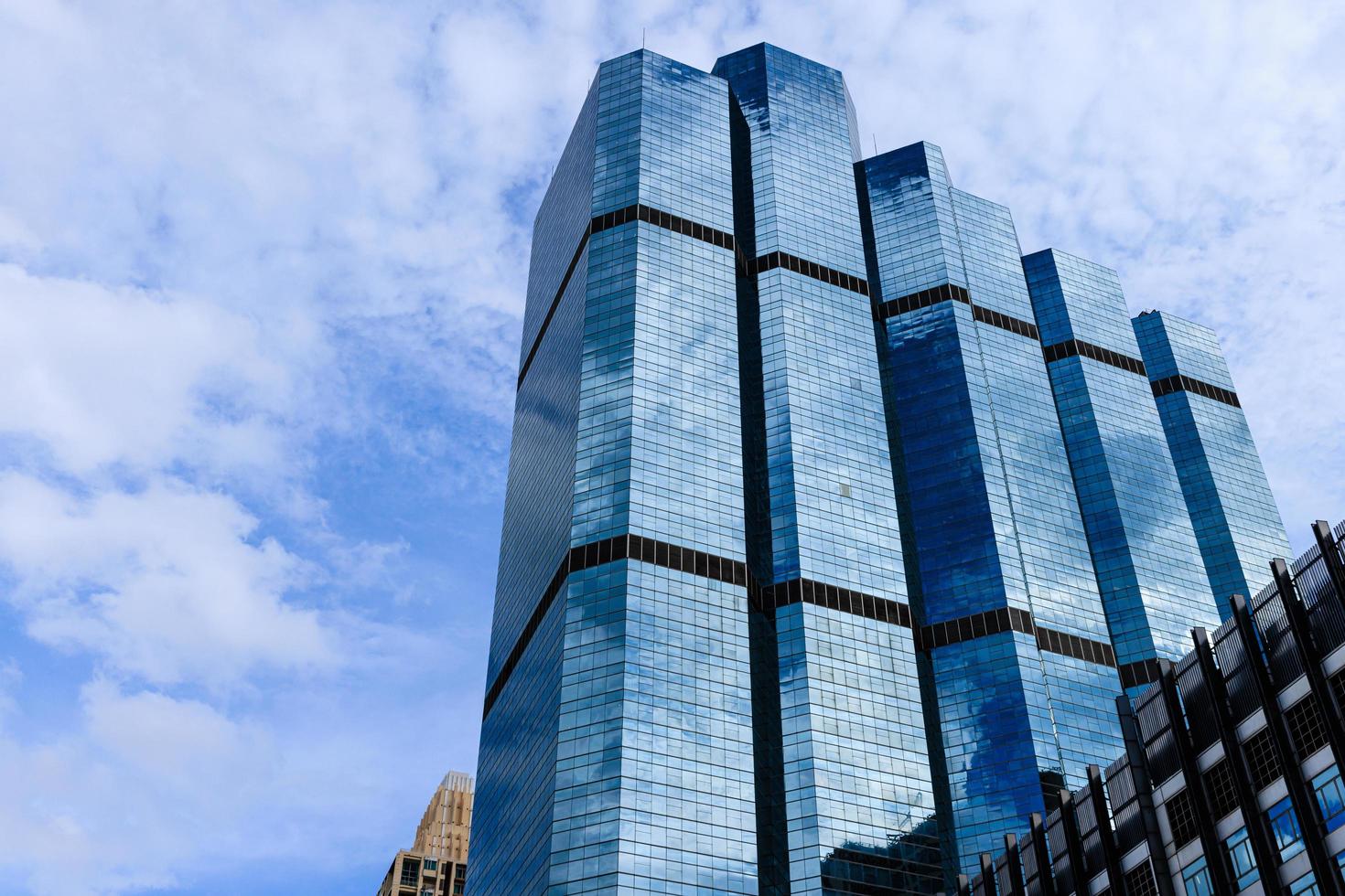 céu azul e nuvens refletidas no vidro de prédios comerciais no centro da cidade em um dia ensolarado. foto