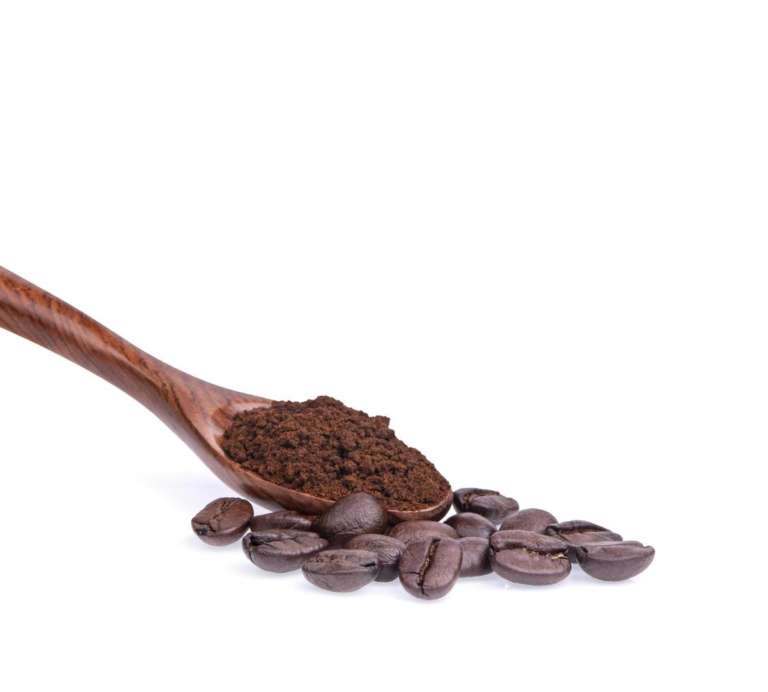 grãos de café com café moído em uma colher em um fundo branco foto