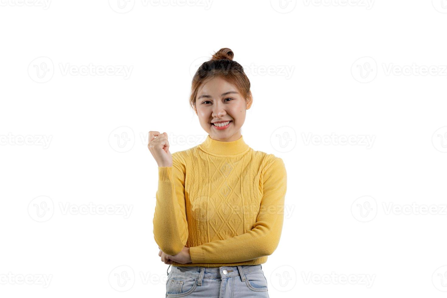 um retrato de uma linda mulher asiática em uma camisa amarela em pé sorrindo alegremente. conceito de retrato usado para propaganda e sinalização, isolado sobre o fundo em branco, copie o espaço. foto