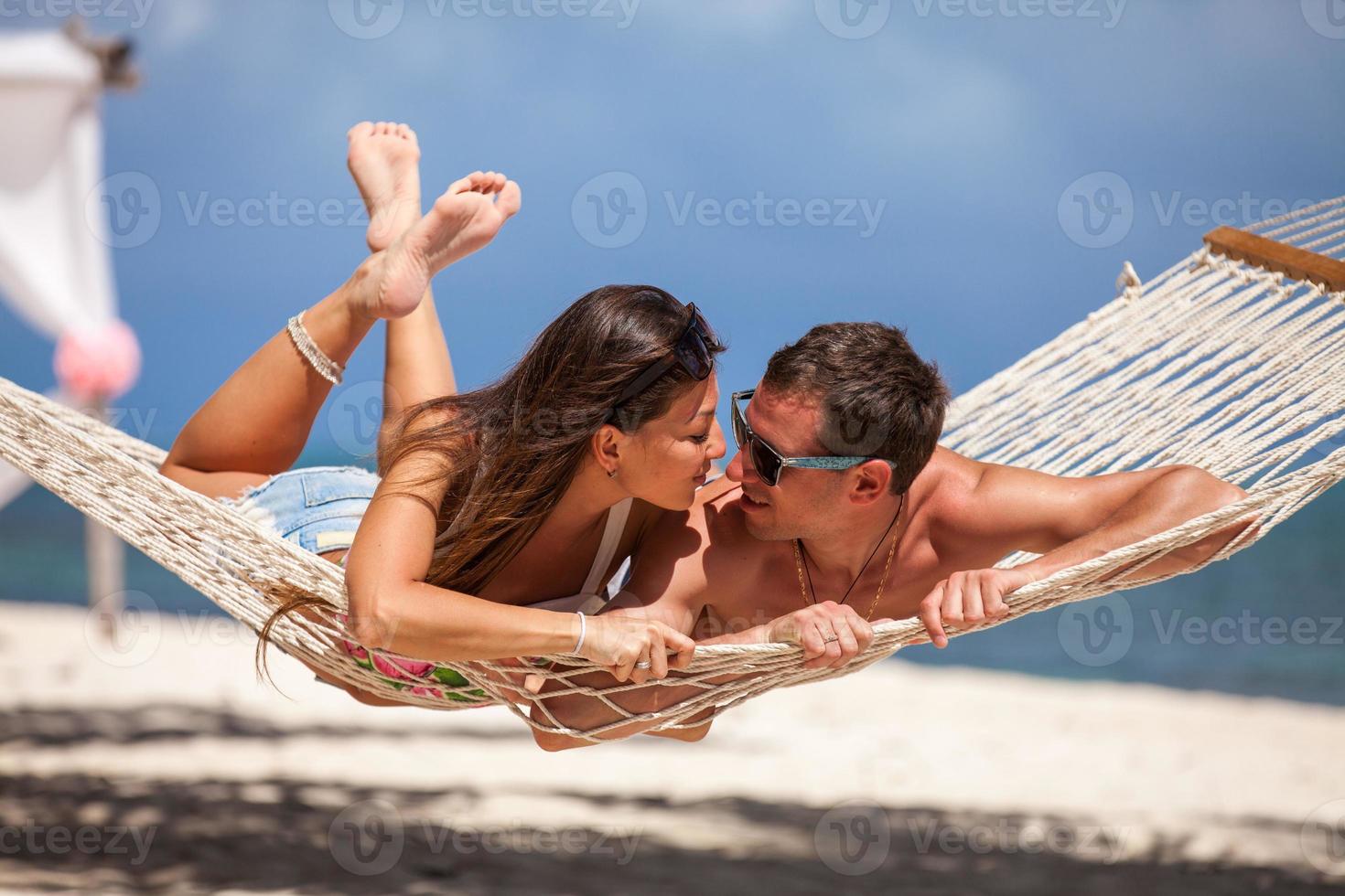 casal romântico relaxante na rede de praia foto