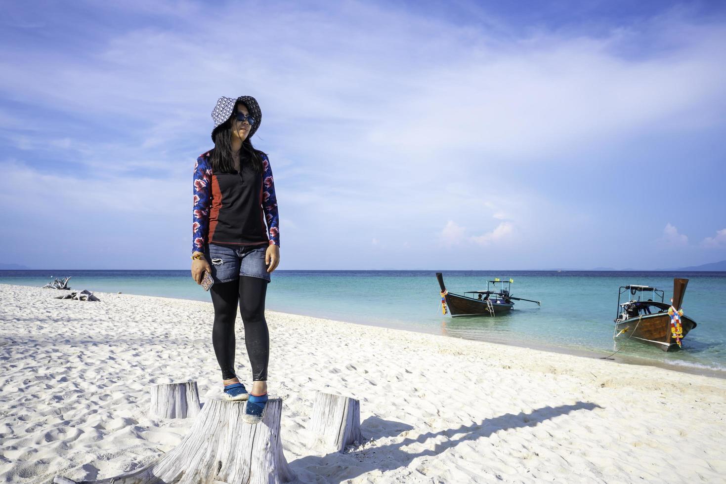 menina asiática em pé olhando para o mar em krabi, tailândia-maya bay beach em phi phi ley island praias de areia branca limpas e mar verde esmeralda. foto