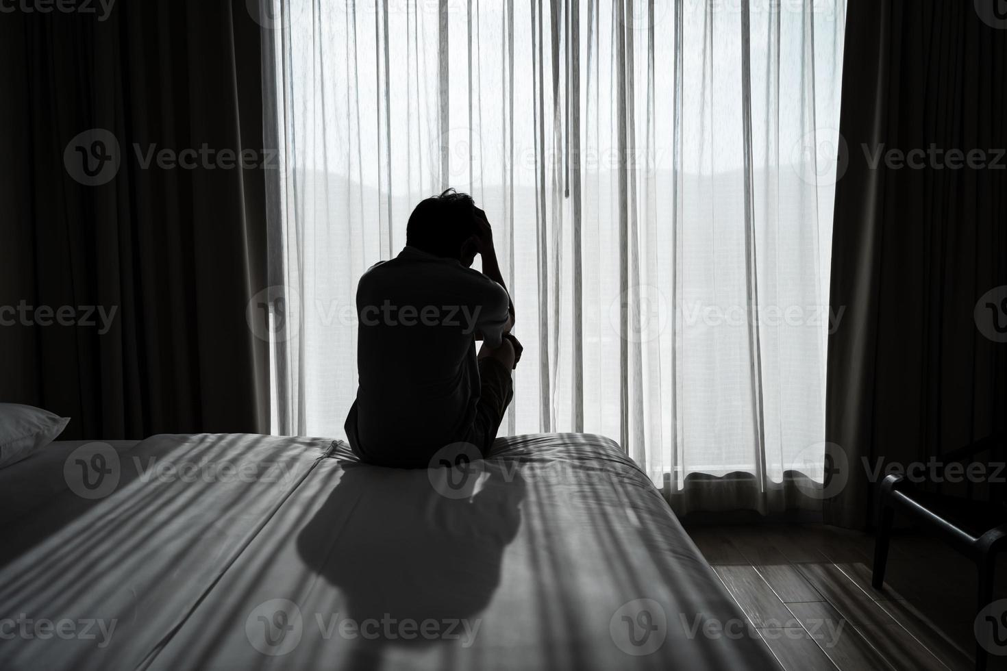 jovem solitário se sentindo deprimido e estressado sentado no quarto escuro, emoção negativa e conceito de saúde mental foto