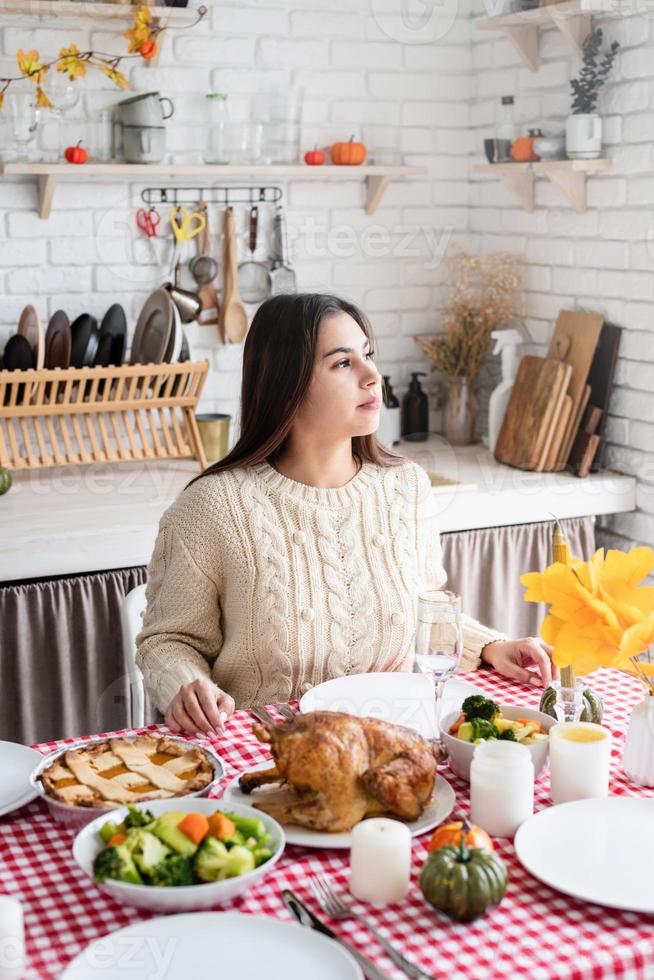 mulher preparando o jantar de ação de graças na cozinha de casa, decorando foto