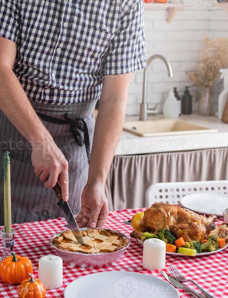 homem preparando o jantar de ação de graças na cozinha de casa foto