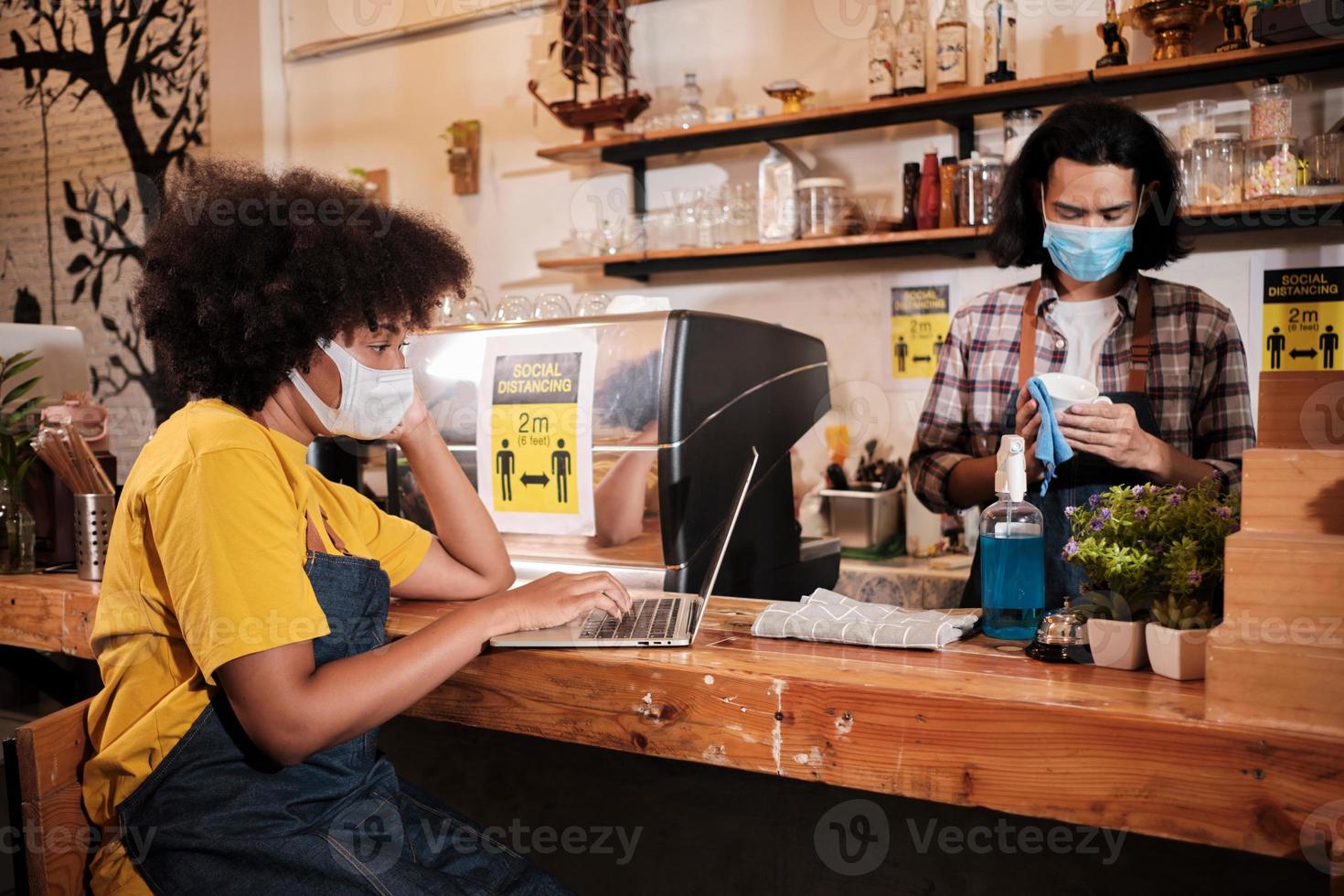 dois jovens parceiros de café barista e empresário trabalham com máscara facial no café, aguardando o pedido dos clientes no novo serviço de estilo de vida normal, impacto nos negócios da quarentena pandêmica covid19. foto