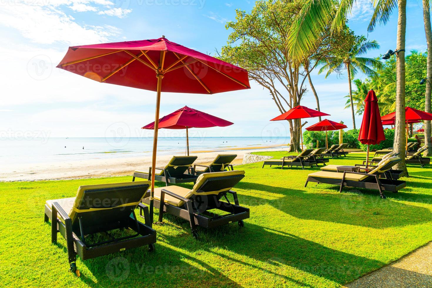 guarda-sol e cadeira de praia com fundo de praia e céu azul foto