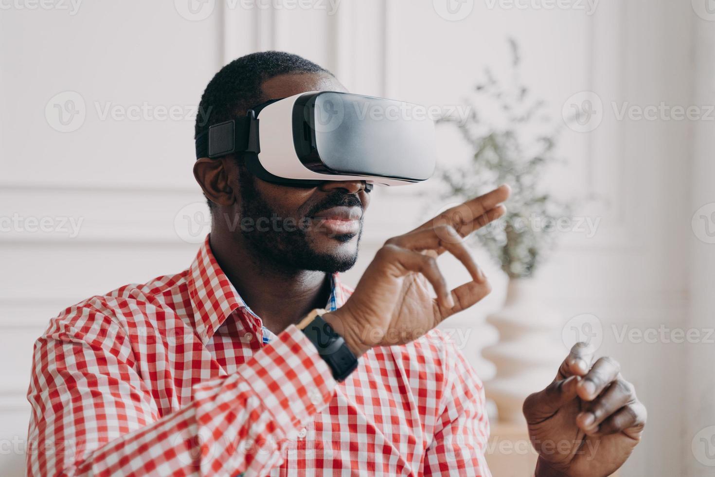 jovem empresário africano usando óculos vr tocando objetos 3d, interagindo com realidade virtual foto