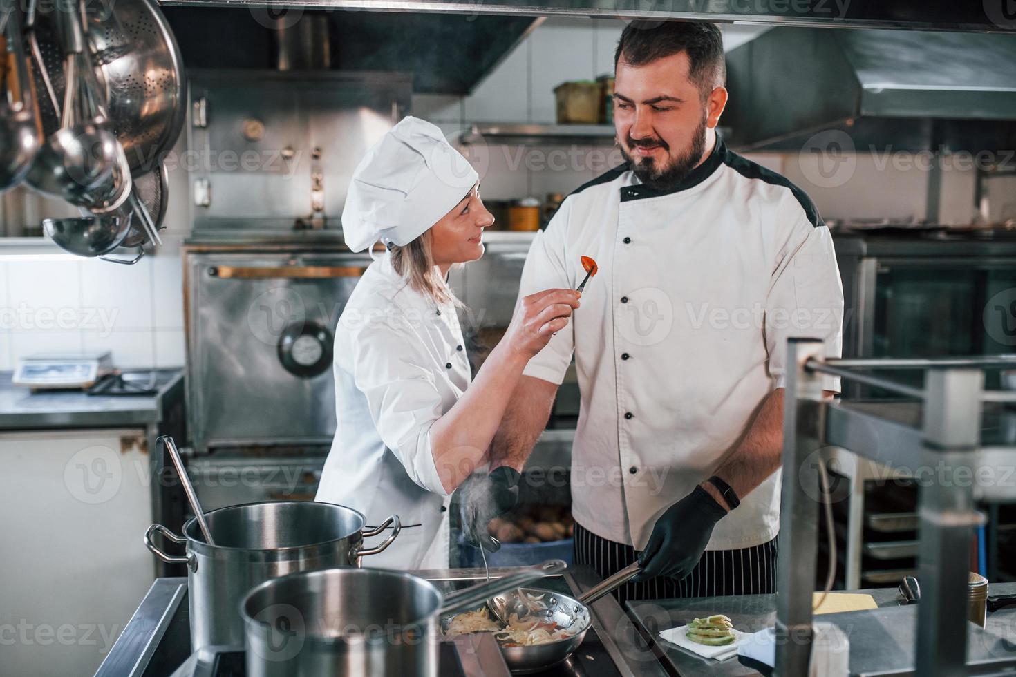 mulher e homem acordando juntos. chef profissional preparando comida na cozinha foto