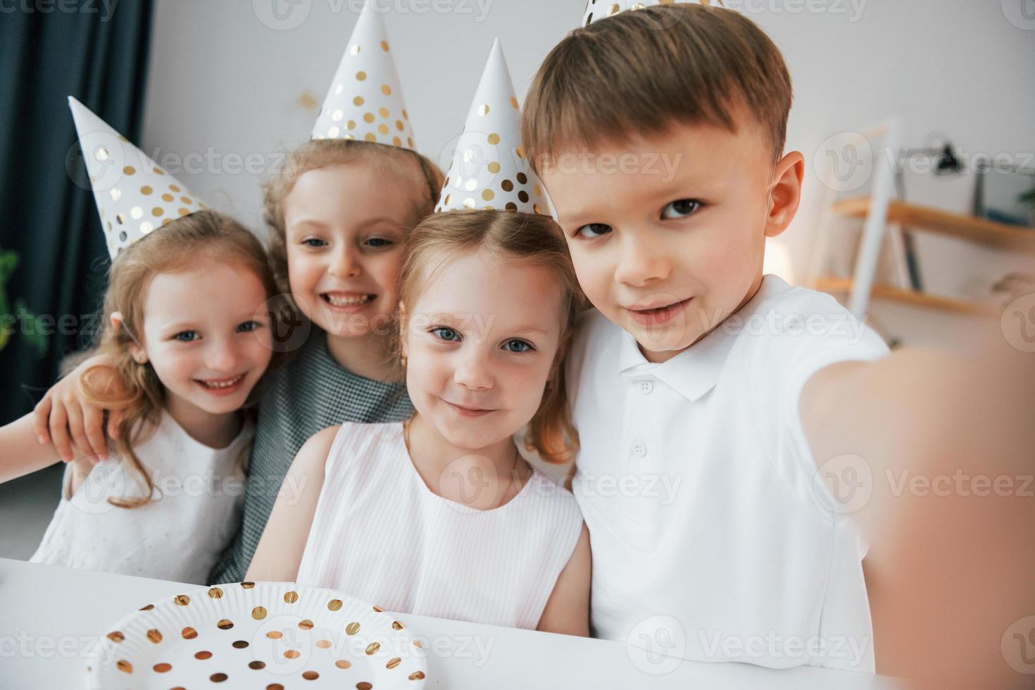 fazendo selfie. comemorando o aniversario. grupo de crianças está junto em casa durante o dia foto