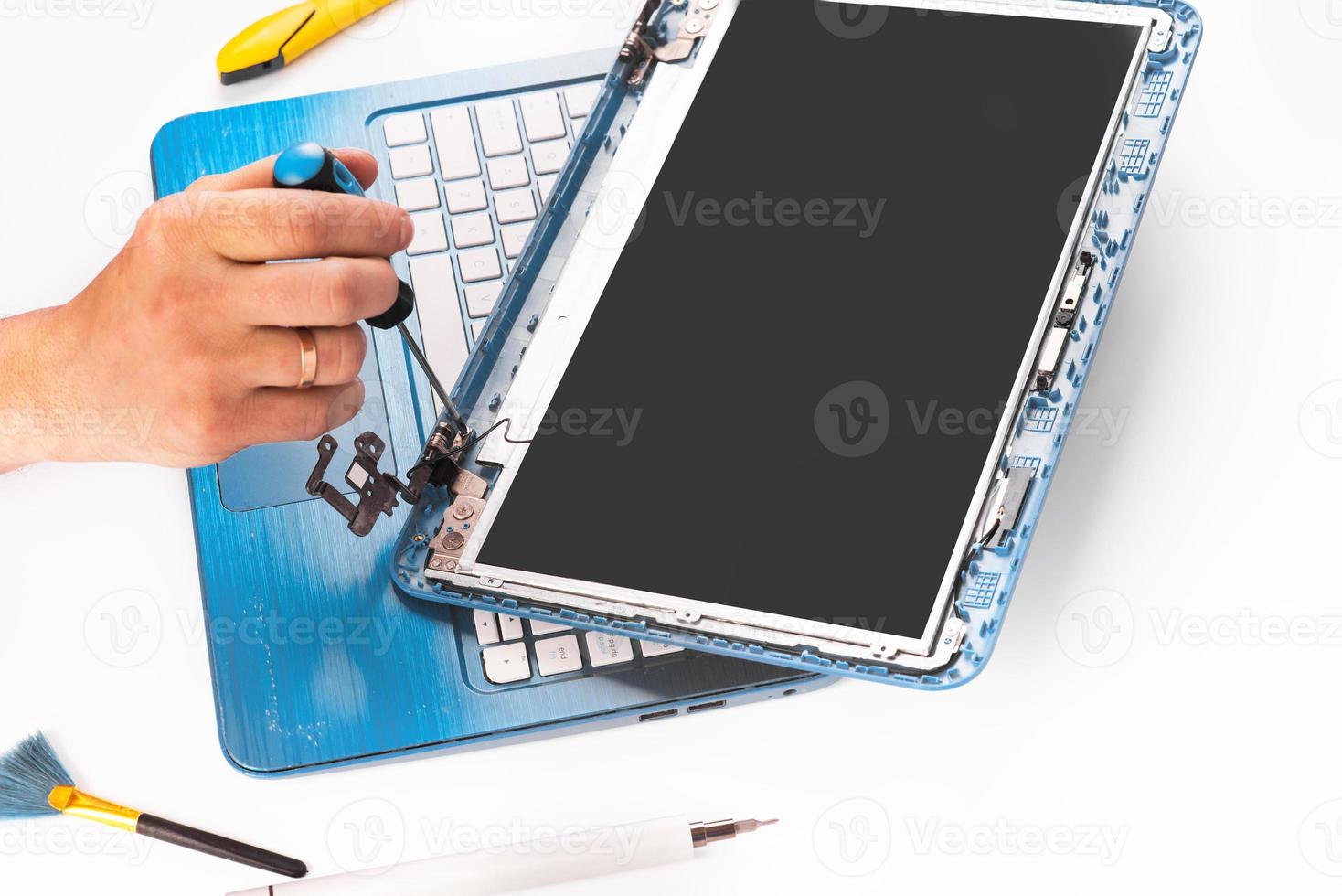 o engenheiro repara laptop azul, pc, computador e a tela. substituição da tela do notebook. instala a CPU do equipamento foto