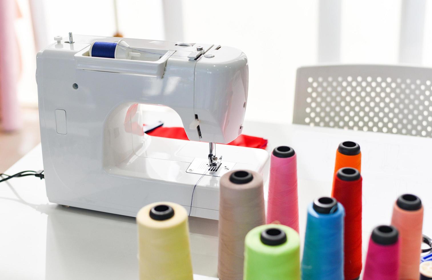ferramentas de costura artesanal com linha de agulha para designer de moda em estúdio material têxtil tesoura corte tecido roupas máquina de costura para designer que trabalha profissional foto