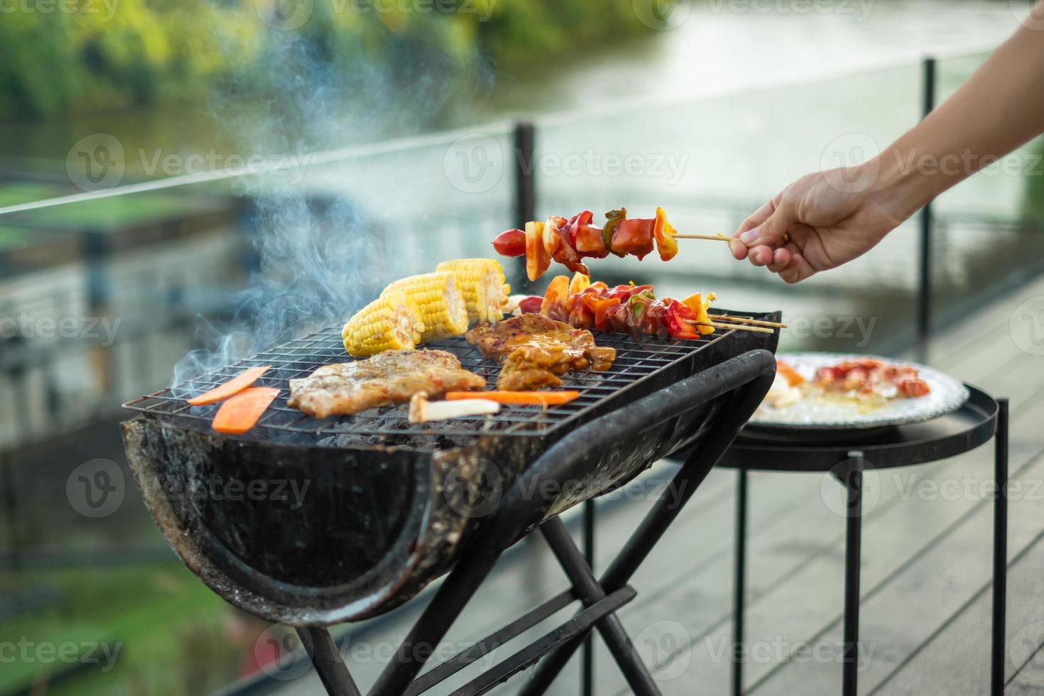 deliciosa carne grelhada com fumaça, churrasco com legumes ao ar livre. churrasco, festa, estilo de vida e conceito de piquenique foto