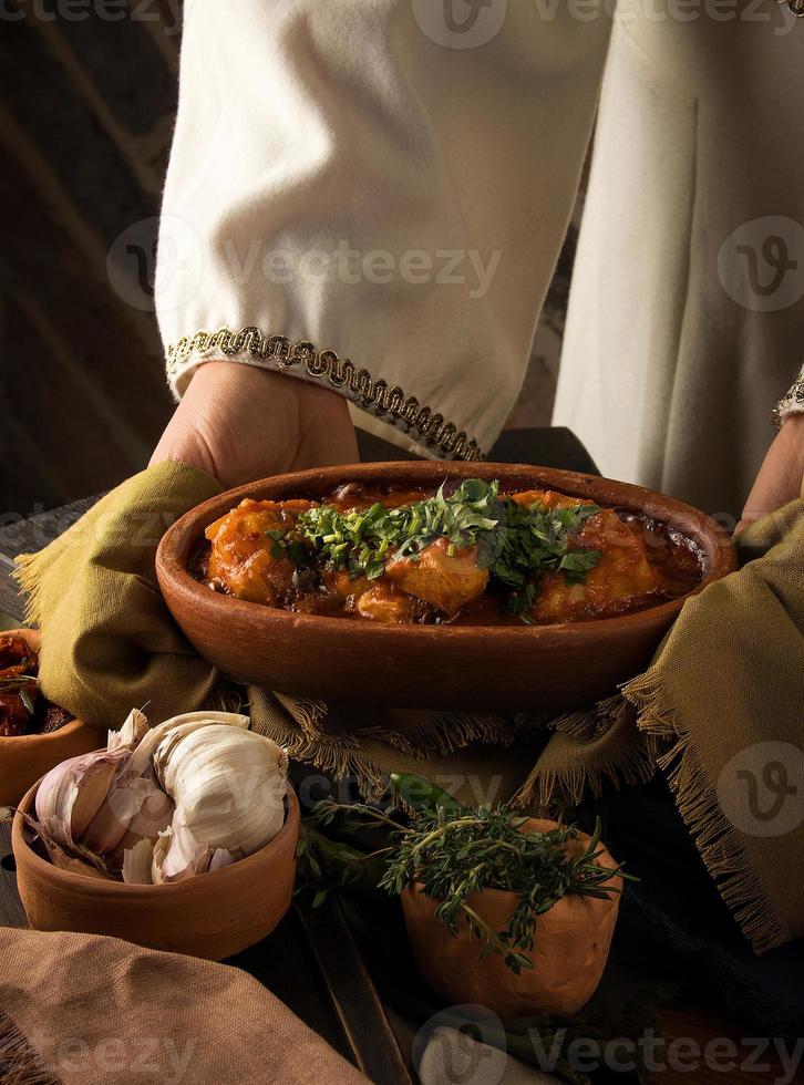 uma garçonete apresentando um ensopado de frango foto