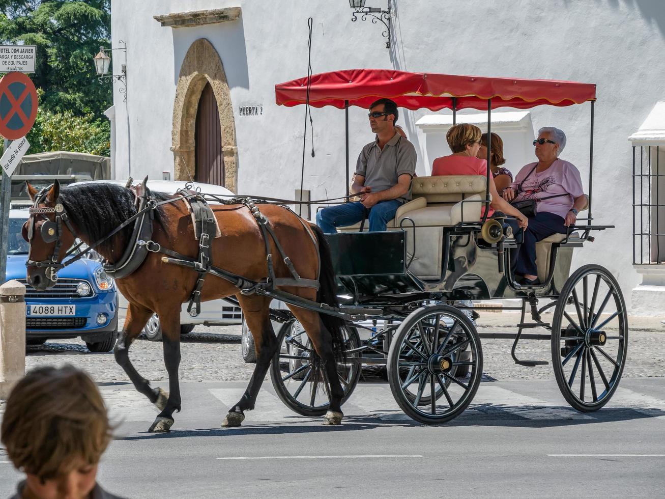 ronda, andalucia, espanha, 2014. turistas desfrutando de um passeio em uma carruagem puxada por cavalos em ronda espanha em 8 de maio de 2014. pessoas não identificadas. foto