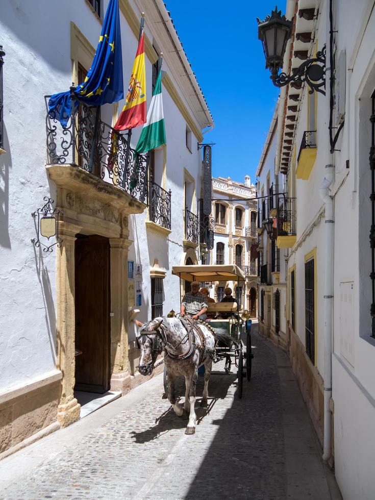 ronda, andalucia, espanha, 2014. turistas desfrutando de um passeio em uma carruagem puxada por cavalos em ronda espanha em 8 de maio de 2014. três pessoas não identificadas. foto