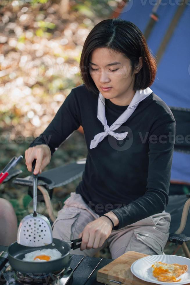 mulheres jovens cozinhando ovo frito foto