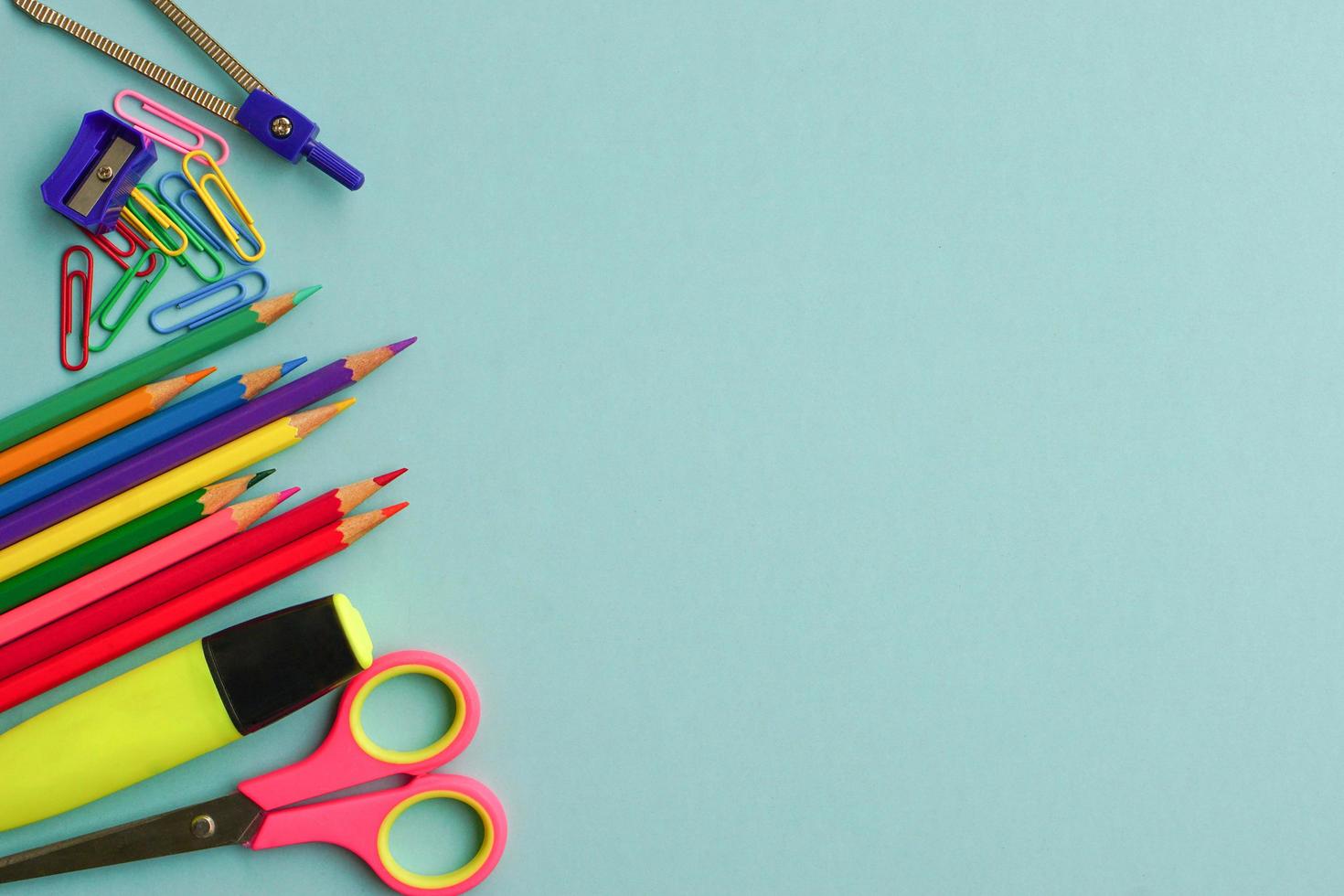 vista superior de material escolar e material de escritório em fundo azul. aprendizagem, estudo, equipamento de escritório e conceito de apresentação. foto