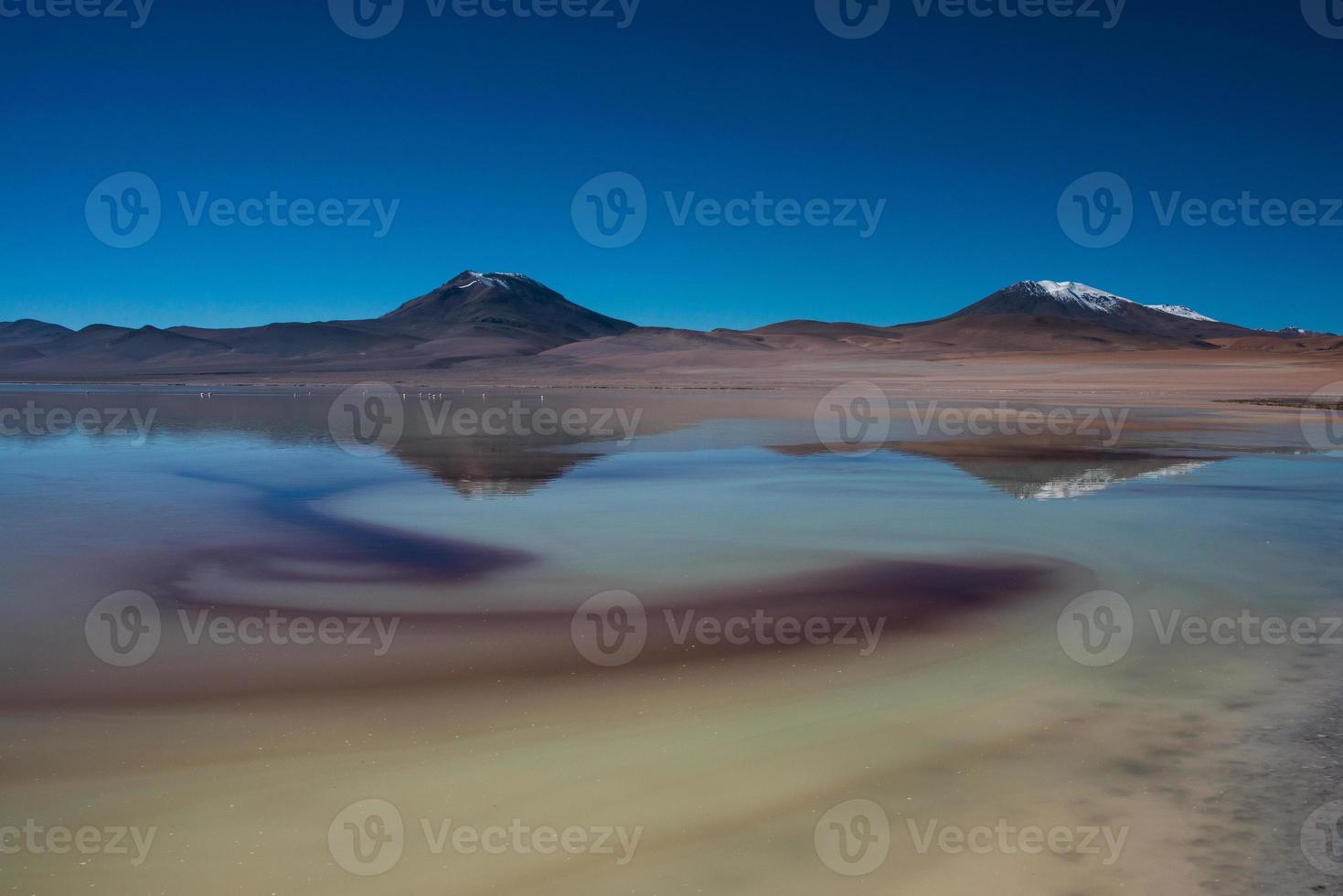 lago de sal com reflexo de montanhas ao fundo foto