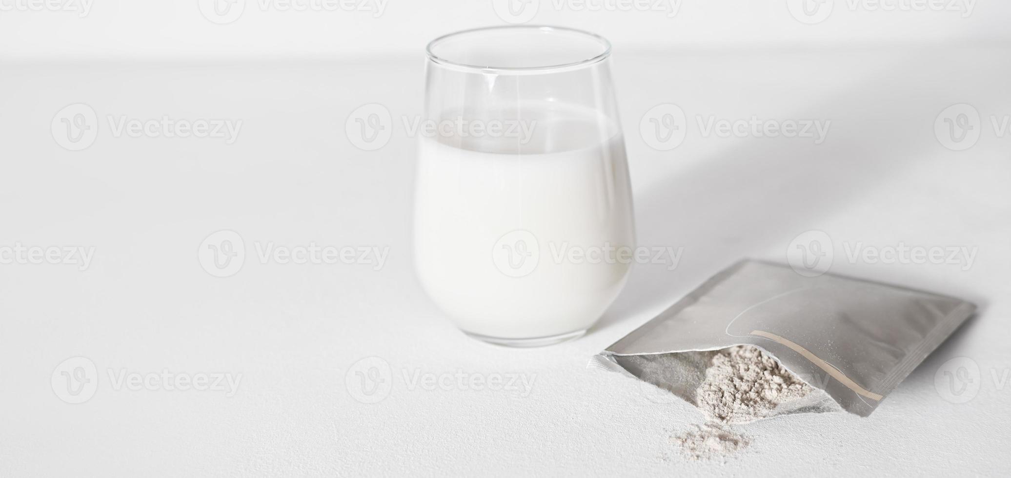 mão segurando o pacote de viagem em pó de colágeno e adicionando-o a um leite para fazer coquetel de proteínas. peptídeos de colágeno em pó para milkshake saudável. cuidados com as articulações. banner, copie o espaço foto