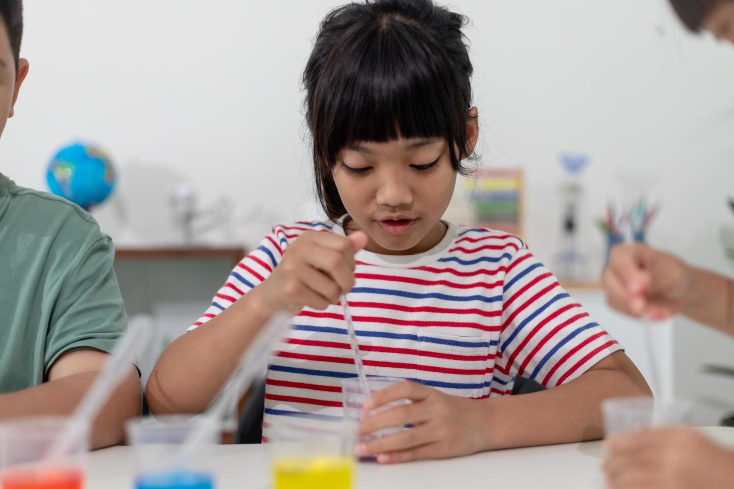 crianças asiáticas fazem experimentos químicos em sua casa foto