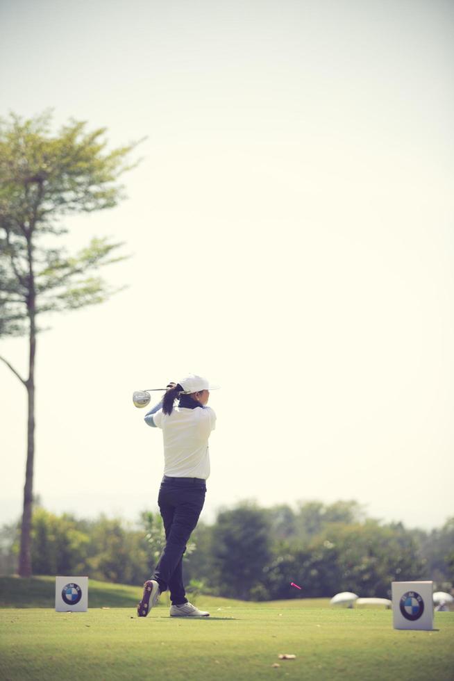os jogadores de golfe atingem o campo de golfe arrebatador no verão.cor vintage foto