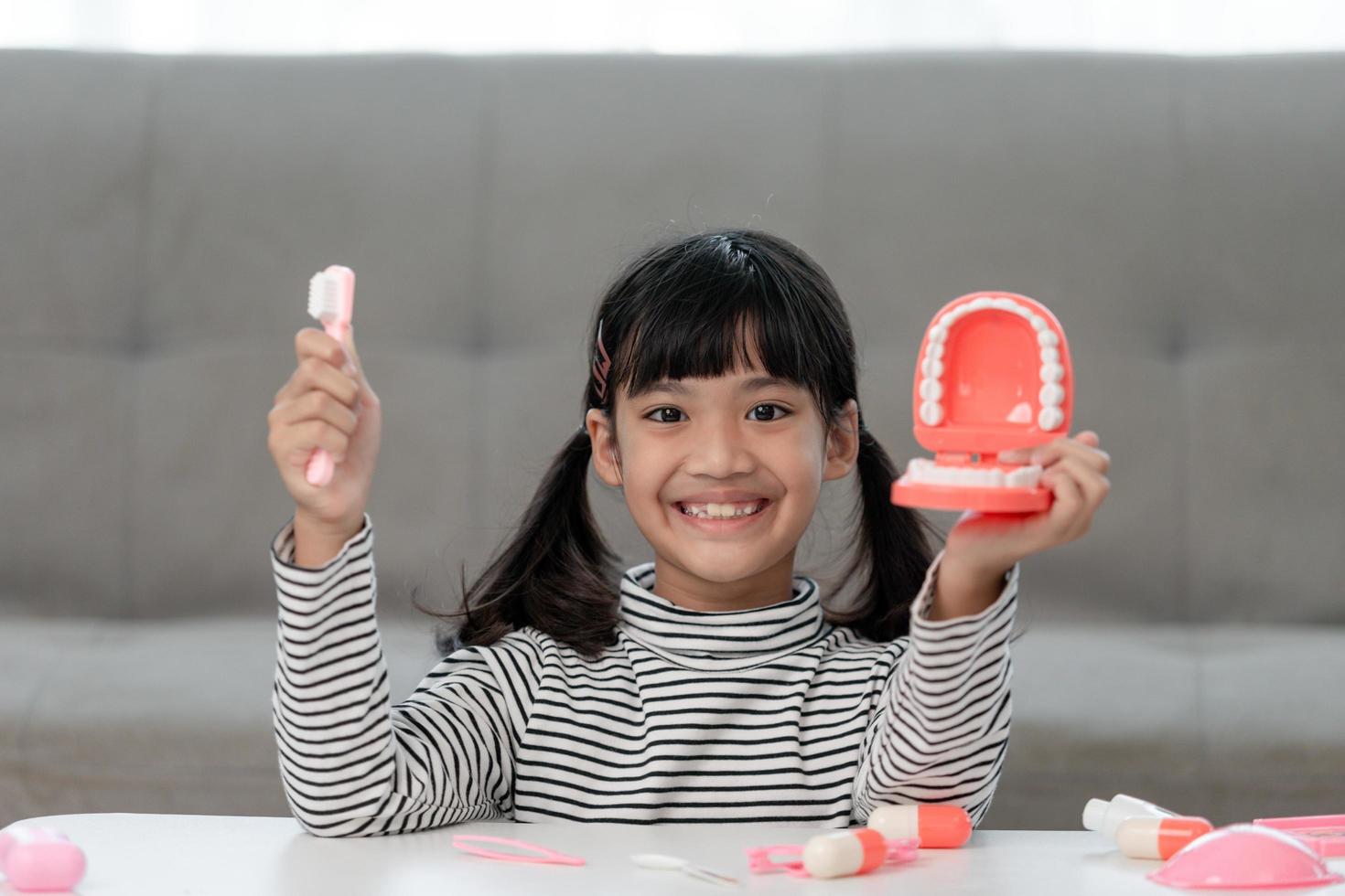 uma criança pequena brinca com mandíbulas artificiais. odontologia infantil. foto