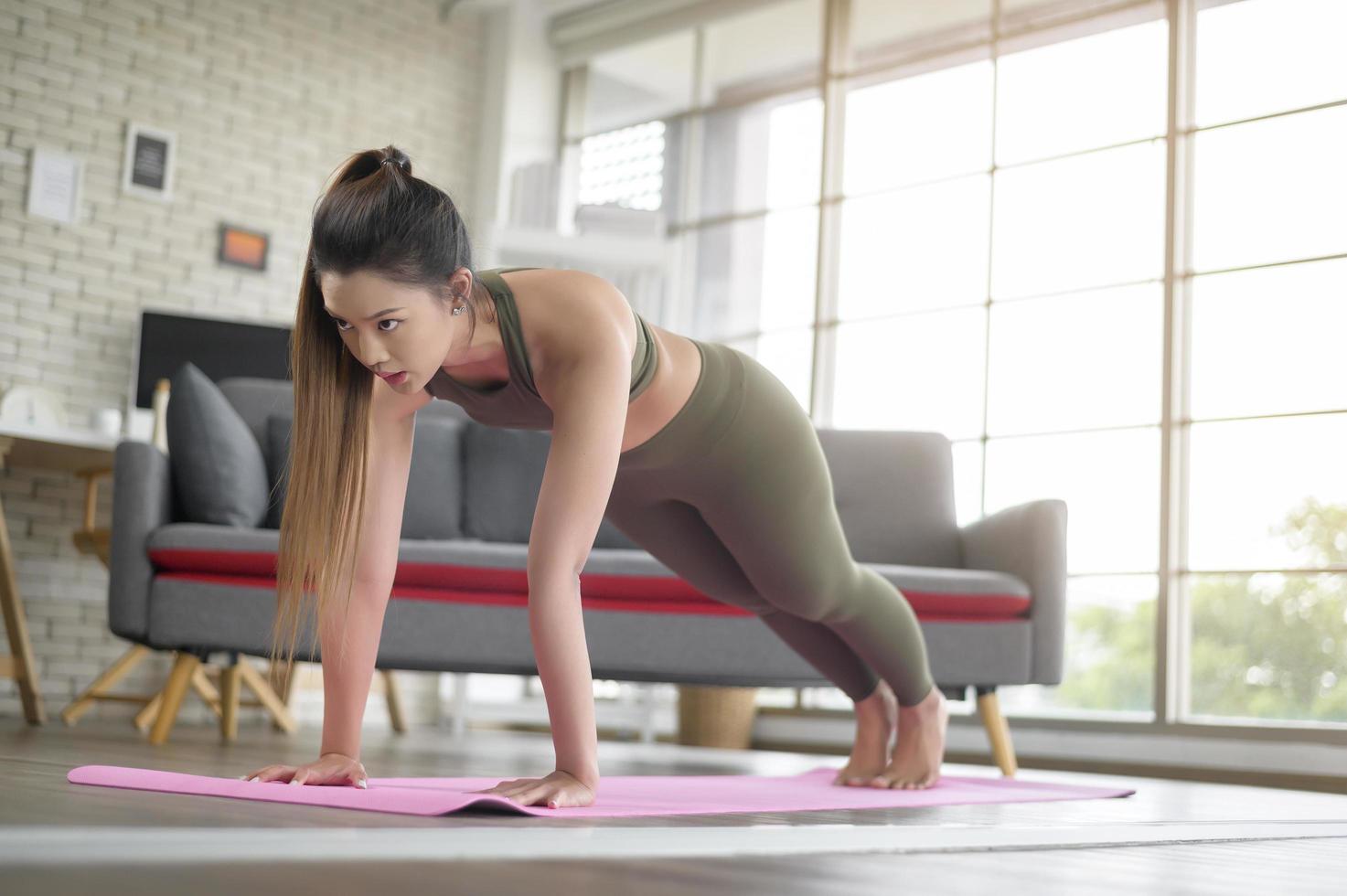 mulher jovem fitness em roupas esportivas se exercitando em casa, saudável e estilos de vida. foto