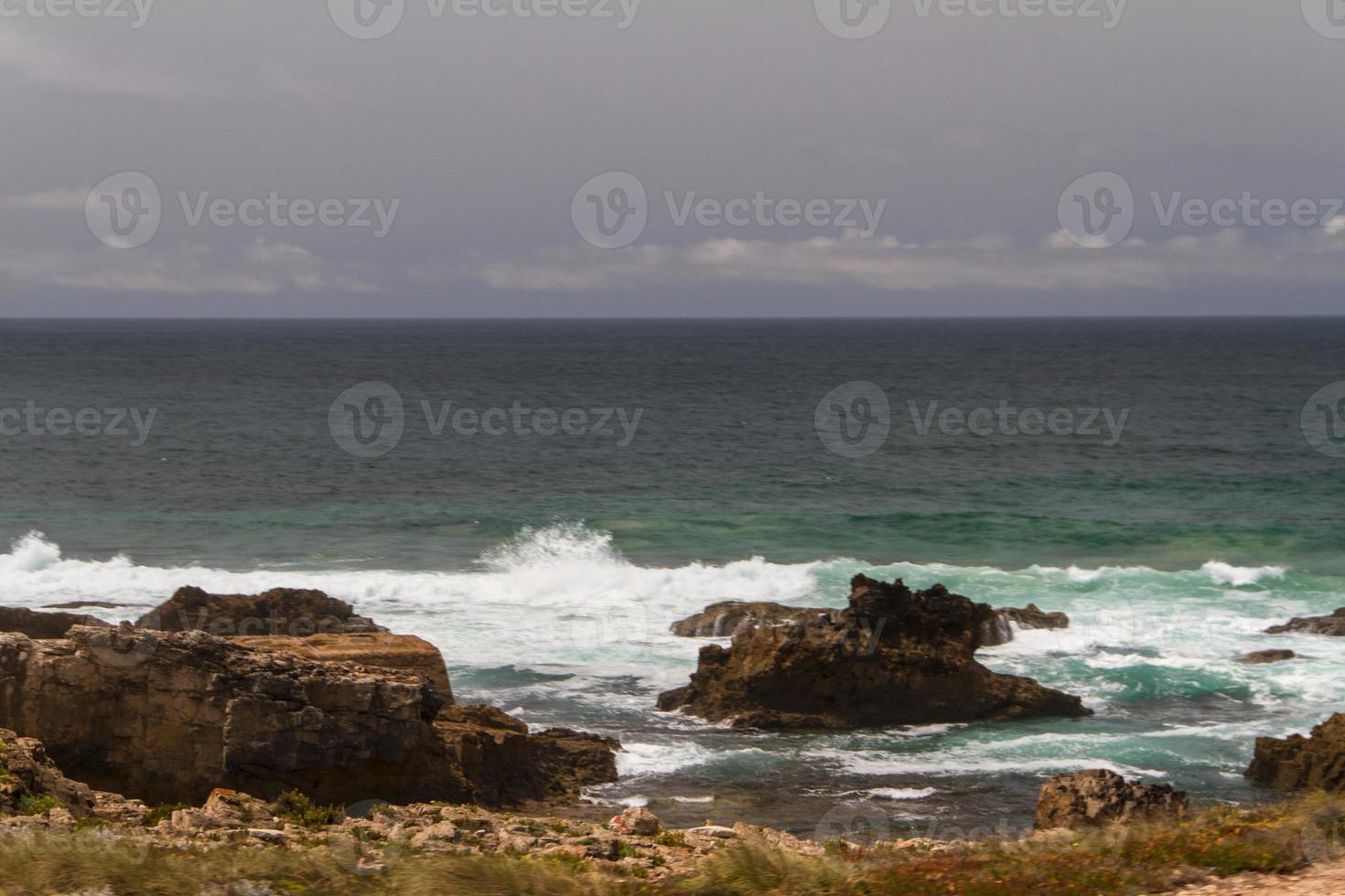 as ondas lutando sobre a costa rochosa deserta do oceano atlântico, portugal foto