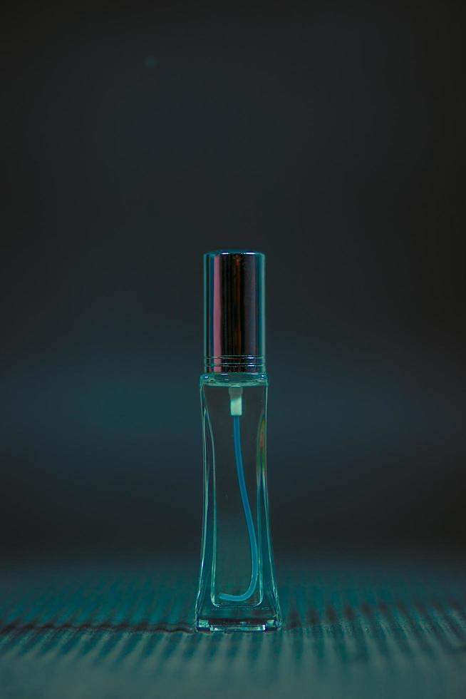 frasco de perfume em cima da mesa, fundo preto foto