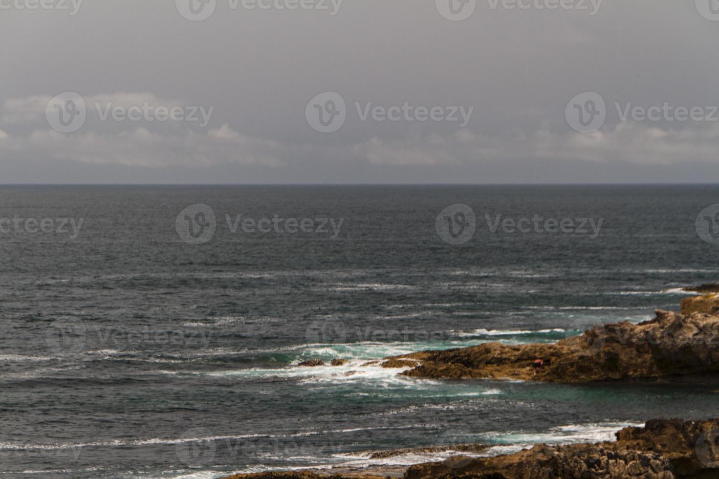 as ondas lutando sobre a costa rochosa deserta do oceano atlântico, portugal foto