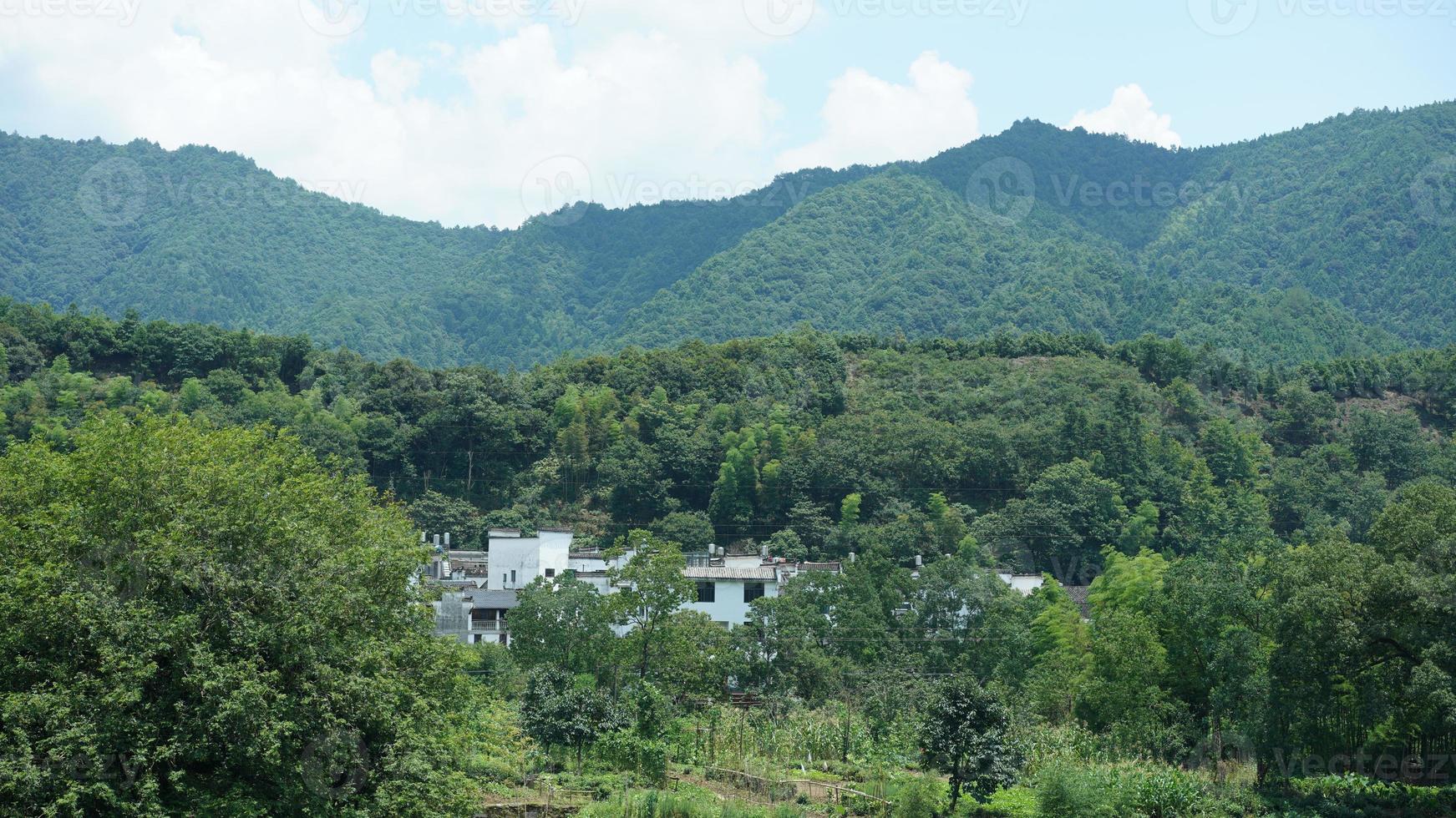 a bela vista da vila rural chinesa com os antigos edifícios tradicionais cercados pelo ambiente natural foto