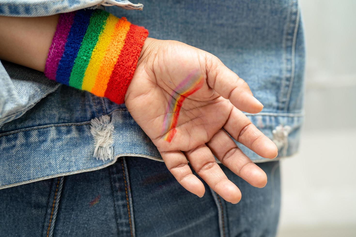 senhora asiática usando pulseiras de bandeira do arco-íris, símbolo do mês do orgulho LGBT, comemora anual em junho social de gays, lésbicas, bissexuais, transgêneros, direitos humanos. foto