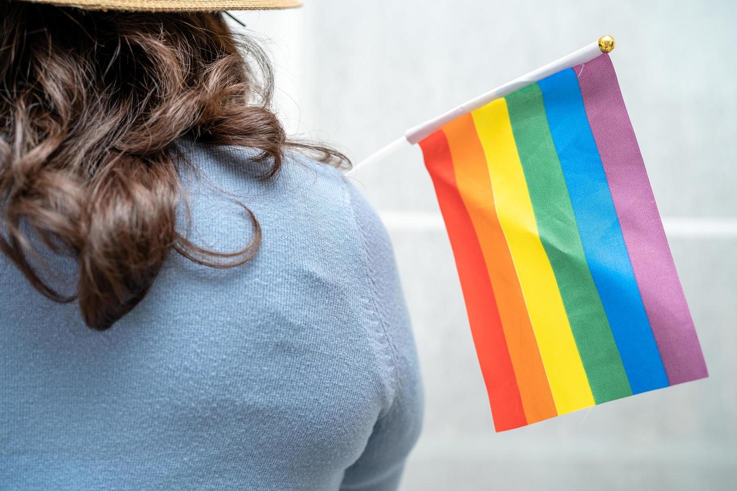 senhora asiática com coração de bandeira do arco-íris, símbolo do mês do orgulho lgbt comemora anual em junho social de gays, lésbicas, bissexuais, transgêneros, direitos humanos. foto