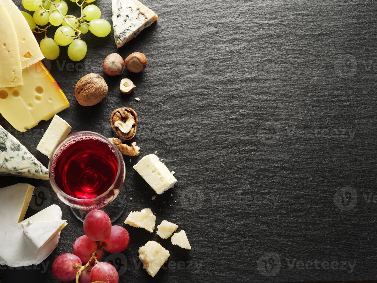tipos de queijos com copo de vinho e frutas. foto