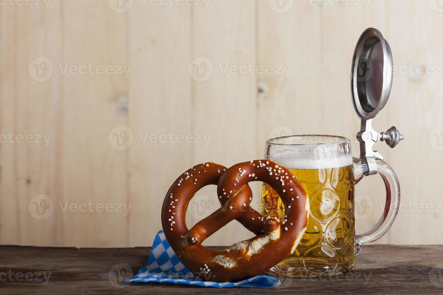 cerveja da Baviera e um pretzel na madeira foto