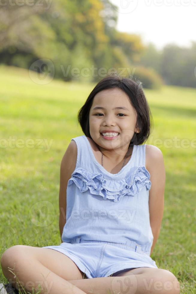menina asiática sorrindo alegremente no parque foto