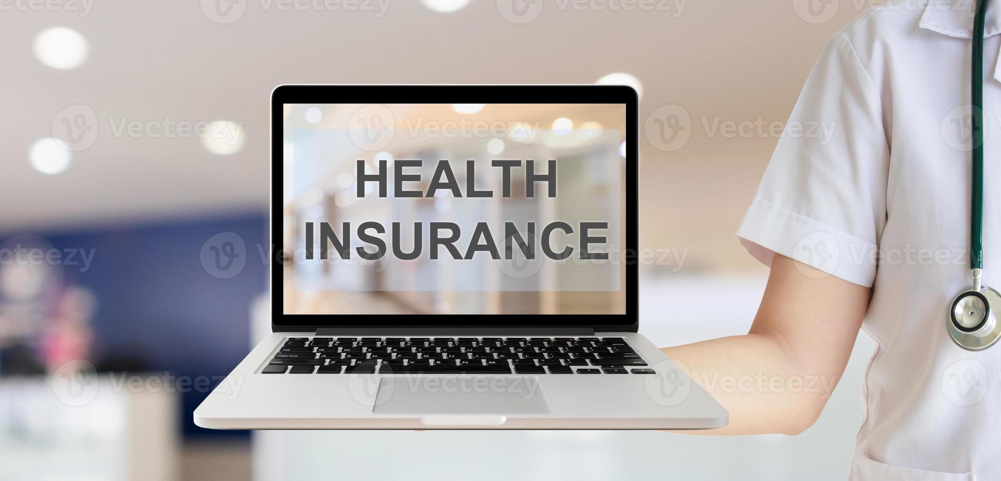 médica mostrando computador portátil com texto de seguro de saúde com conceito de saúde de fundo de quarto de hospital desfocado foto