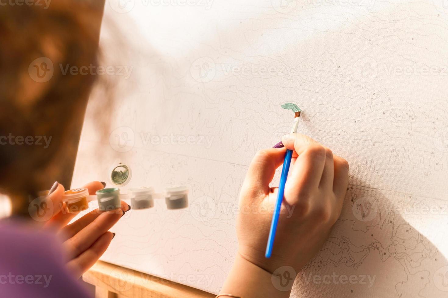 a mulher adulta pintando por números dentro de casa foto