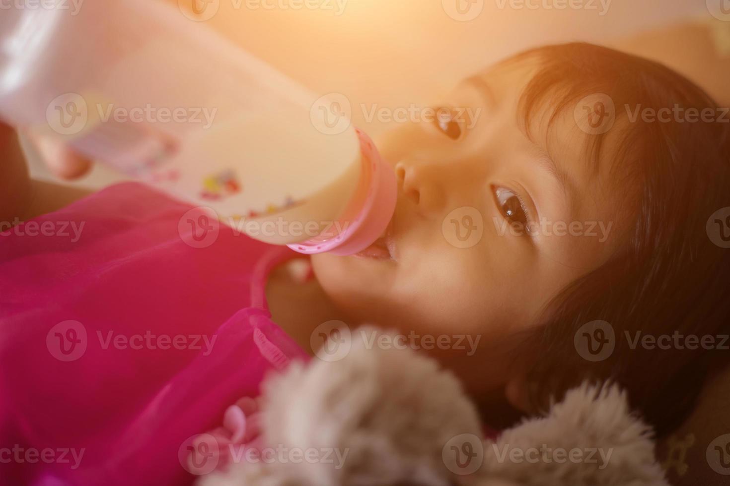 menina feliz no boné brincando com ursinho de pelúcia no parque de verão foto