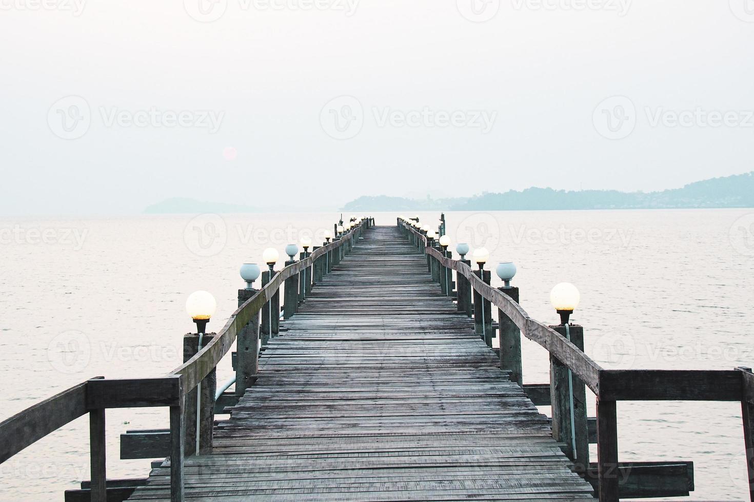 uma passarela de madeira que se estende até o mar. conceito de viagem de férias foto