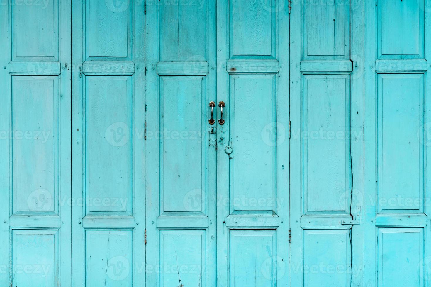 porta de madeira verde ou azul fechada. abstrato da porta da frente vintage. casa velha abandonada. textura de porta de madeira velha. foto