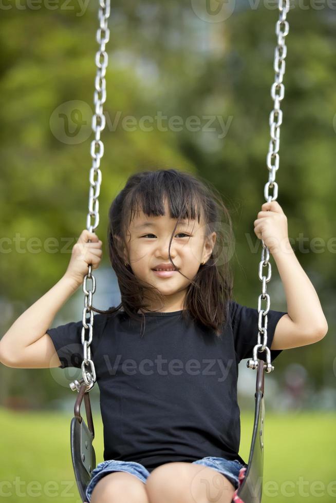 jovem menina asiática brincando alegremente no parque foto