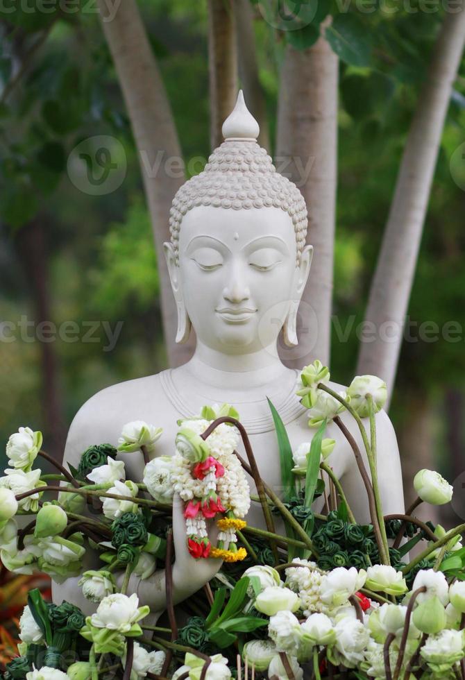 adoração ao budismo com oferta de flores e guirlanda para estátua de buda em magha puja, asalha puja e visakha puja dia na tailândia foto