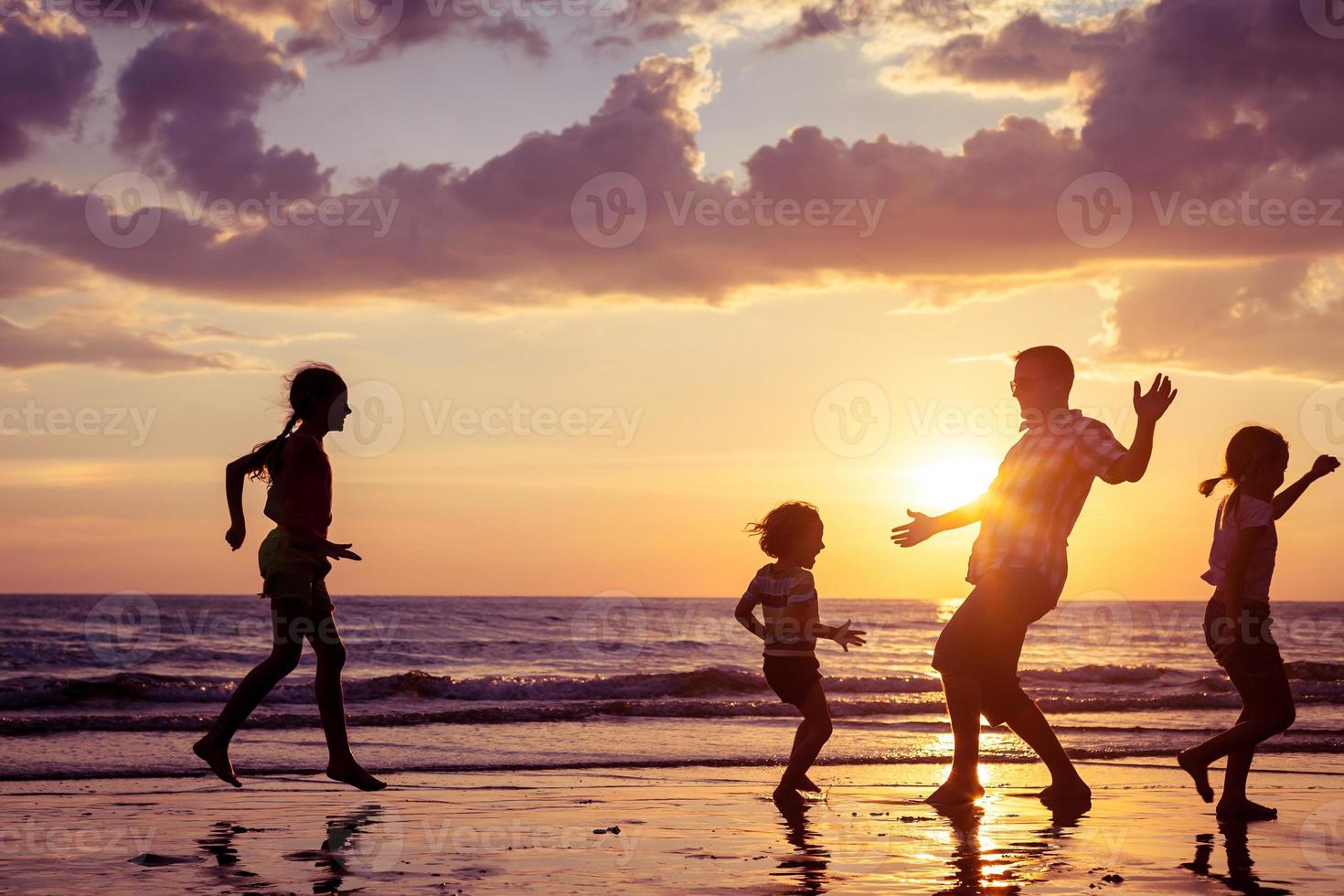 pai e filhos brincando na praia foto